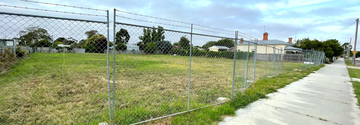 Planning due diligence checks - image of vacant block with wire fence around it.
